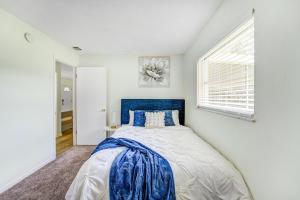 a bedroom with a blue bed and a window at Quiet Location Duplex House - Minutes Away from Everything - Winter Park, Florida in Orlando
