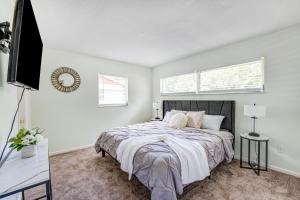 a bedroom with a bed and a flat screen tv at Quiet Location Duplex House - Minutes Away from Everything - Winter Park, Florida in Orlando