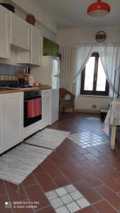 cocina con armarios blancos y suelo de baldosa roja en La casetta del Pastore en Sulmona