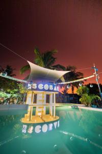 a resort with a swimming pool at night at Mozambeat Motel in Praia do Tofo