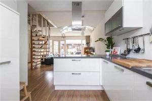een keuken met witte kasten en een houten vloer bij Cozy Dutchie House Near Utrecht in Nieuwegein