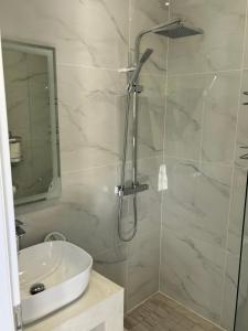 W łazience znajduje się szklana kabina prysznicowa i umywalka. w obiekcie Modern cottage on the sea w mieście Vathi