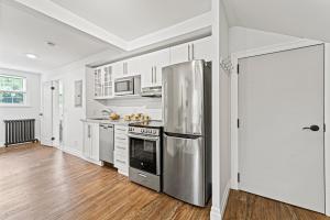 a kitchen with a stainless steel refrigerator and white cabinets at Elegant 1Bdrm Apt Near Downtown Burlington Ideal for long stays U4 - Amelia in Burlington