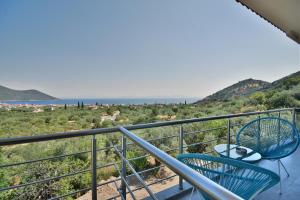 balkon z 2 krzesłami i oceanem w tle w obiekcie Konatsi Luxury Apartments w mieście Tyros