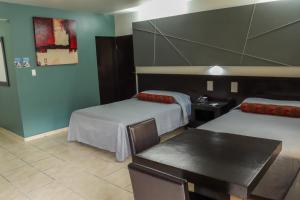 a hotel room with two beds and a table at Hotel La Mesa in Tijuana