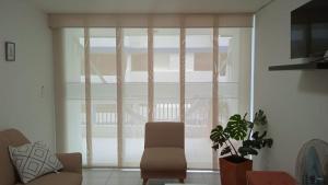 a living room with a chair and a large window at Apartamento karey 506 in Santa Marta +15 photos