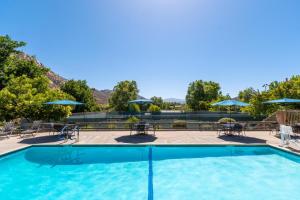 uma piscina com mesas, cadeiras e guarda-sóis em San Diego Country Estates em Ramona