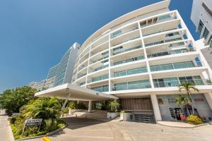ein großes weißes Gebäude mit Palmen davor in der Unterkunft Edificio Morros 3 in Cartagena de Indias