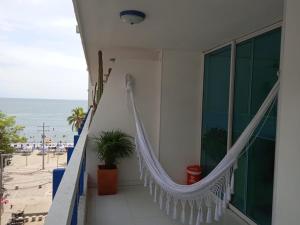a balcony with a hammock and a view of the beach at Apartamento karey 506 in Santa Marta