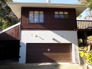 a house with a garage door and a balcony at Protea Guest House in Knysna