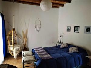 1 dormitorio con 1 cama azul y 1 silla en Brisas de viñedos en Luján de Cuyo