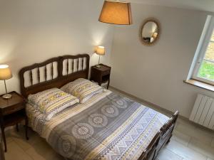 1 dormitorio con 1 cama con 2 almohadas y espejo en Gite en pleine nature, en Manciet