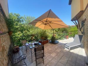 un patio con mesa y sombrilla en The House by the River Luxury Villa, en Veria