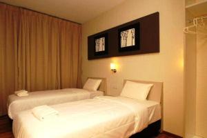 a hotel room with two beds and two windows at Ipoh Boutique Hotel in Ipoh