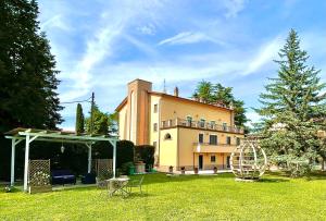 een groot gebouw in een tuin met een boom bij HOLIDAY HOUSE VILLA CAMILLA Luxury Apartment in Perugia