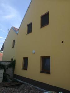 a yellow building with windows on the side at Ing. Martin Čech Kielar in Hlohovec