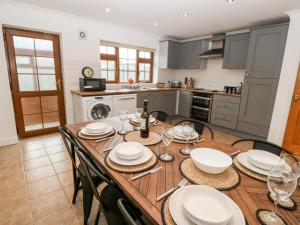 a kitchen and dining room with a wooden table and chairs at Yr Hen Efail in Cemaes Bay