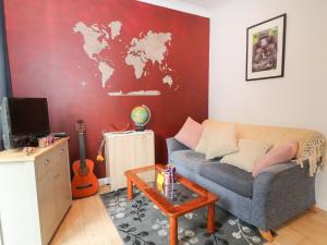 a living room with a couch and a red wall at Awdry Bungalow in Beaworthy