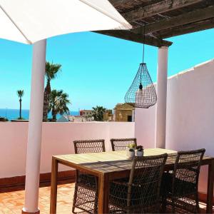 stół i krzesła na tarasie z widokiem na ocean w obiekcie Casa La Mata w mieście Torrevieja