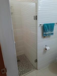 a bathroom with a shower with a blue towel at Departamento Moderno Alberca Compartida - 6 Personas in Mazatlán