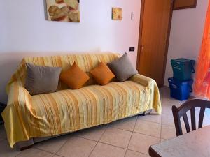 a couch with pillows on it in a living room at Holiday mode EVA in Partinico