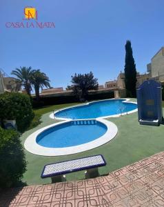 basen w ogrodzie z ławką obok niego w obiekcie Casa La Mata w mieście Torrevieja
