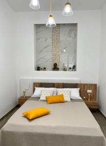 ein Schlafzimmer mit einem großen Bett mit zwei gelben Kissen in der Unterkunft Sunshine in Santa Maria di Castellabate