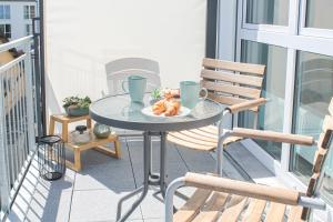 a table with a plate of food on a balcony at Tropical Apartment - für Freunde & Familien, stadtnah, Parkplatz, E-Ladestation, Gitterbox für Fahrräder, Fitnessstudio, digitale Gästemappe mit Restaurant- und Unternehmenstipps in Koblenz