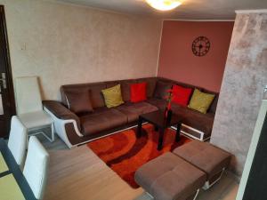 sala de estar con sofá marrón y mesa en Casa Crissio, en Sinaia