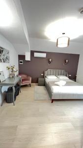 a bedroom with a large bed and a table at Pensiunea Heaven in Alba Iulia