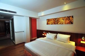 a bedroom with a bed and a painting on the wall at French Hotel in Ipoh