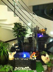 a aquarium with a fountain in a room with plants at French Hotel in Ipoh