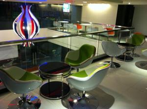 a group of chairs and a glass table with a vase at French Hotel in Ipoh