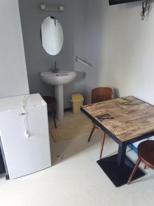 een keuken met een tafel en een wastafel en een tafel en stoelen bij hotel de la gare in Verchamp