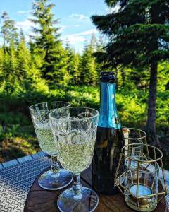 two wine glasses and a bottle on a table at Glamping Tent with amazing view in the forest in Torsby