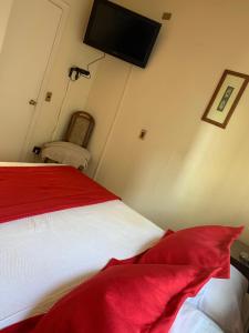 a bedroom with a red and white bed and a tv on the wall at Hotel Marina Azul in Viña del Mar