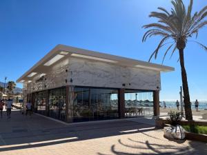 フエンヒロラにあるModerno Apartamento en Primera línea Paseo Marítimo Fuengirolaのヤシの木のある海辺のレストラン