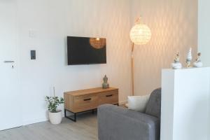 a living room with a couch and a tv at Buddha Apartment in Koblenz