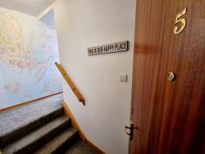 a staircase in a room with a sign on the wall at One Bed Holiday Home in the Heart of Inverness in Inverness