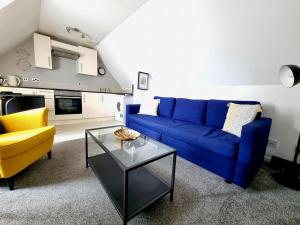 uma sala de estar com um sofá azul e uma mesa em One Bed Holiday Home in the Heart of Inverness em Inverness