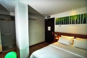 a bedroom with a bed and a large painting on the wall at French Hotel in Ipoh