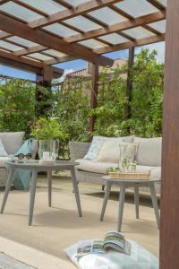 a patio with two tables and a couch and a pergola at Terranam Bed & Breakfast in Catoira