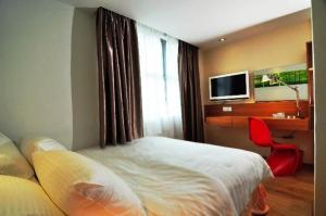 a hotel room with a bed and a television at French Hotel in Ipoh