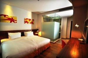 a bedroom with a large white bed and a table at French Hotel in Ipoh