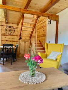 a vase of flowers on a table in a living room at Mokrogorski konaci in Mokra Gora