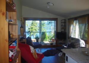 a living room with a large window and a red couch at Wild Coast Chalets in Port Renfrew