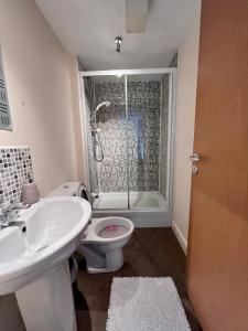 a bathroom with a sink and a toilet and a shower at Lovely 2-Bed Serviced apartment with free parking in Glasgow