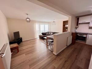 uma sala de estar com um sofá e uma mesa em Lovely 2-Bed Serviced apartment with free parking em Glasgow