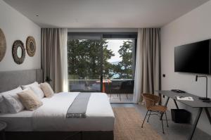 a bedroom with a bed and a desk and a television at La Vista Suites in Zadar