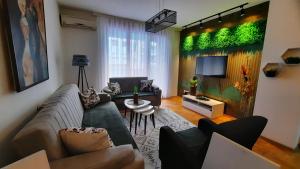 een woonkamer met een bank en een tv bij Jeta Apartment in Pristina